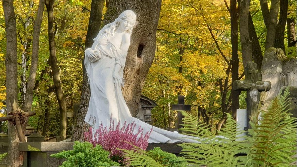 Sculpture of a monument portraying a woman at Powązki Cemetery, Warsaw, Poland - A poignant and artistic monument featuring a woman, evoking solemnity and grace, within the serene surroundings of Powązki Cemetery, a notable resting place for many influential figures in Polish history.