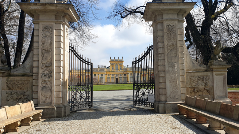 Entrance gate to the Palace of King John III in Wilanów - A regal gateway framing the approach to the majestic Wilanów Palace. Adorned with architectural details and historical significance, this gate serves as a grand introduction to the splendid estate, inviting visitors to explore its rich heritage and opulent surroundings.